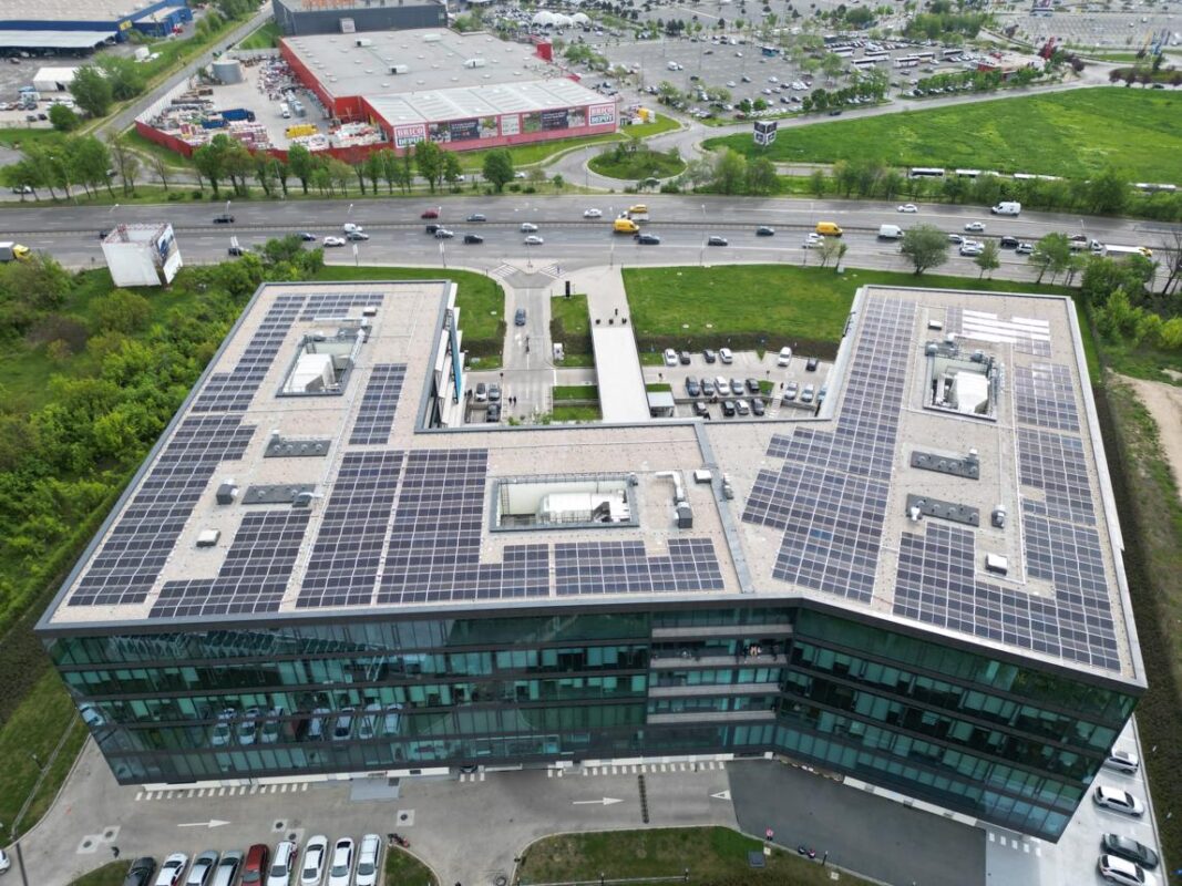Modern commercial building with rooftop solar panels viewed from above